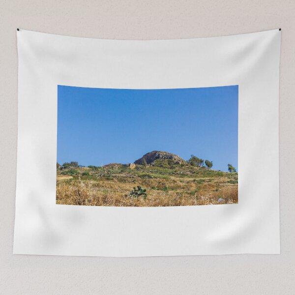 Artikelvorschau, Sonnige mediterrane Hügellandschaft mit Felsvorsprüngen, terrassierten Hängen und trockenem Gras unter blauem Himmel entworfen und verkauft von Nmallia.