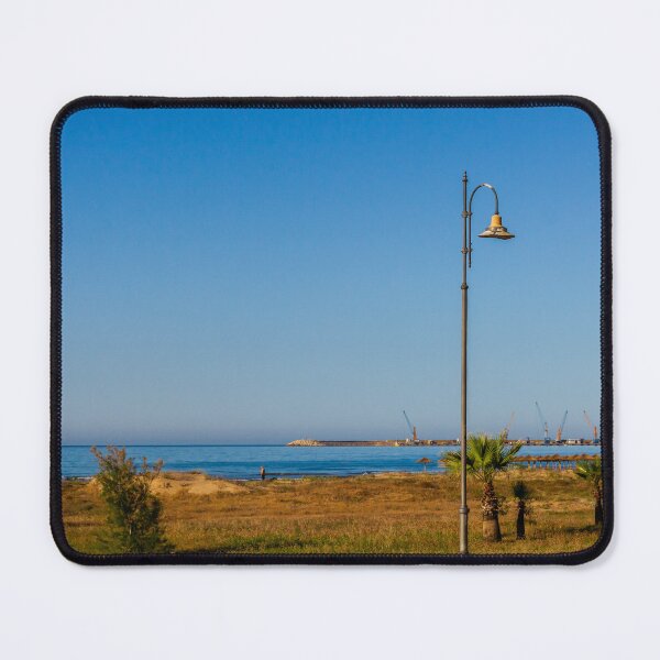 Item preview, Coastal Promenade Lamp Post Overlooking Calm Sea, Sandy Dunes and Distant Harbor Cranes at Sunrise designed and sold by Nmallia.