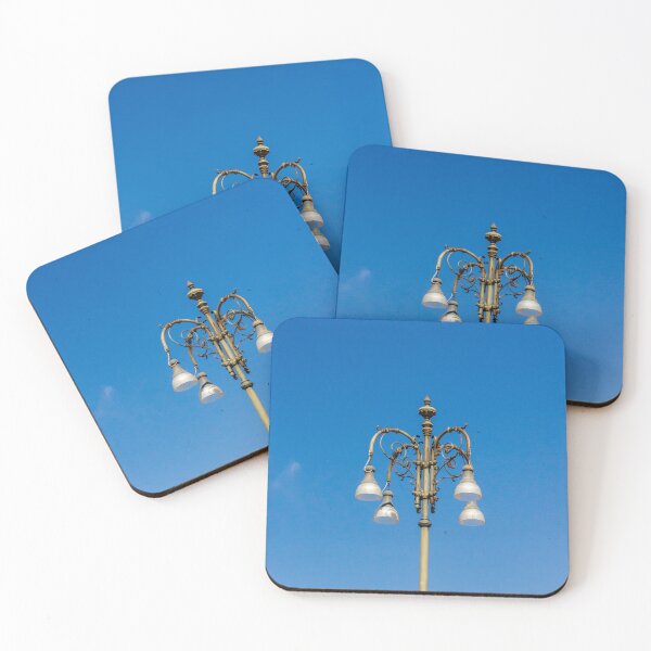 Item preview, Ornate Vintage Street Lamp Against Bright Blue Sky With Elegant Metalwork and Hanging Lights designed and sold by Nmallia.