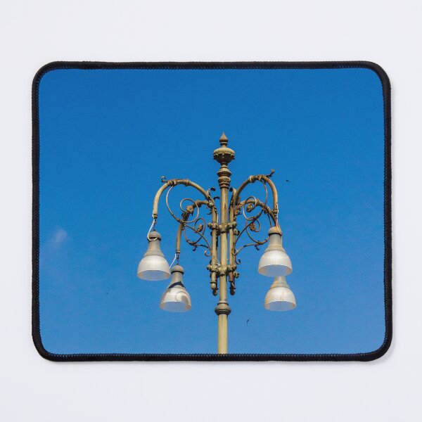 Item preview, Ornate Vintage Street Lamp Against Bright Blue Sky With Elegant Metalwork and Hanging Lights designed and sold by Nmallia.