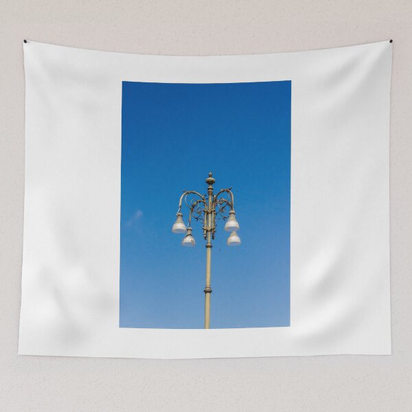 Item preview, Ornate Vintage Street Lamp Against Bright Blue Sky With Elegant Metalwork and Hanging Lights designed and sold by Nmallia.