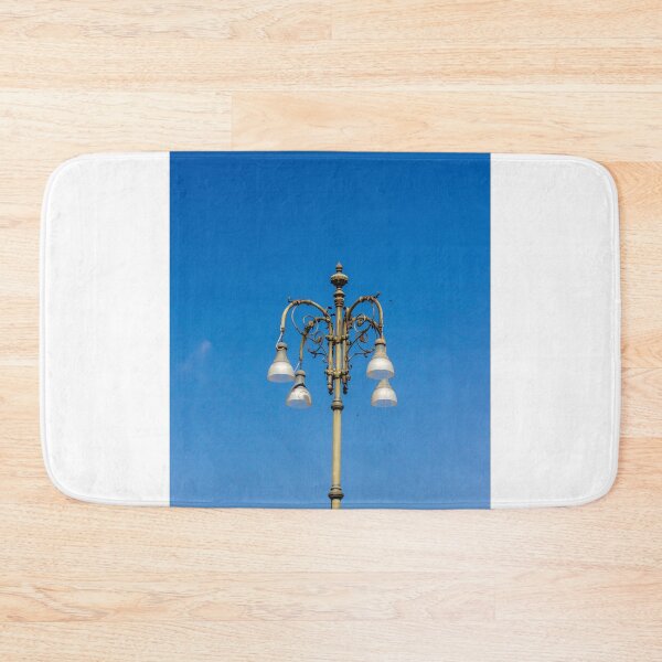Item preview, Ornate Vintage Street Lamp Against Bright Blue Sky With Elegant Metalwork and Hanging Lights designed and sold by Nmallia.