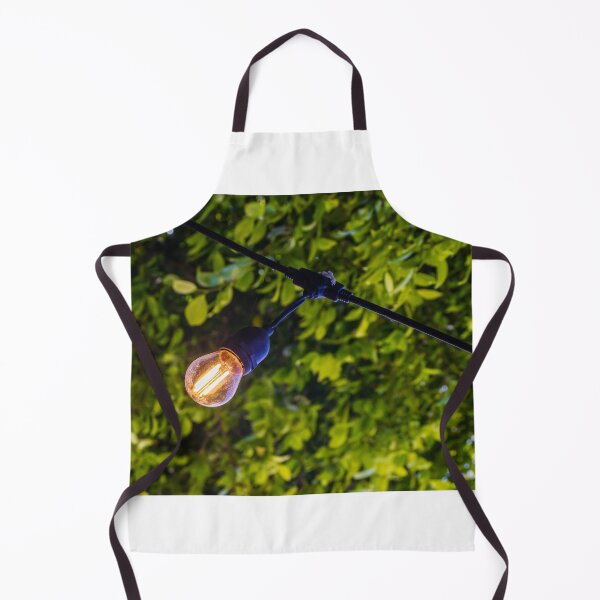 Item preview, Warm Glowing Light Bulb Hanging From Outdoor String Lights Over Lush Green Garden Foliage designed and sold by Nmallia.