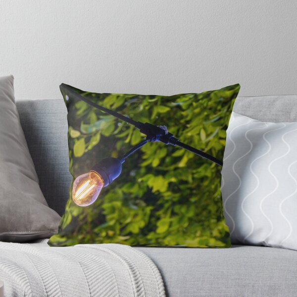 Item preview, Warm Glowing Light Bulb Hanging From Outdoor String Lights Over Lush Green Garden Foliage designed and sold by Nmallia.