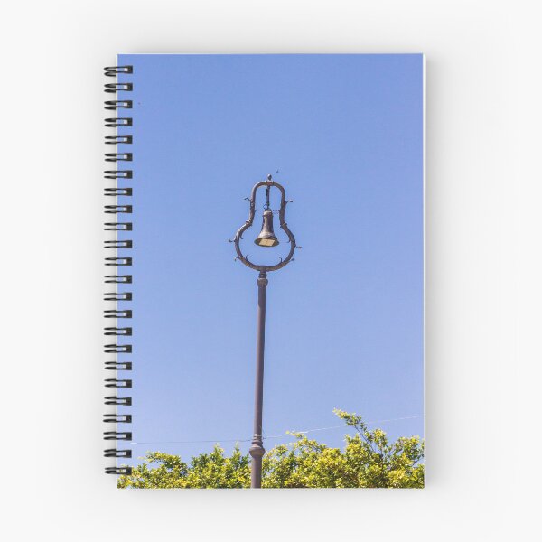 Item preview, Vintage Ornamental Bell Street Lamp Against Clear Blue Sky With Green Foliage designed and sold by Nmallia.