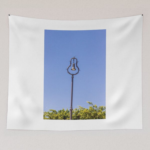 Item preview, Vintage Ornamental Bell Street Lamp Against Clear Blue Sky With Green Foliage designed and sold by Nmallia.