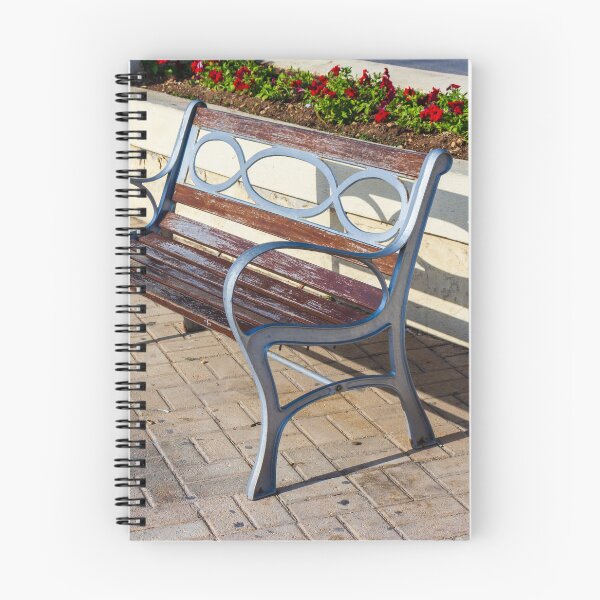 Item preview, Wooden And Metal Park Bench Casting Shadow Along Flowerbed On Sunny Pavement designed and sold by Nmallia.