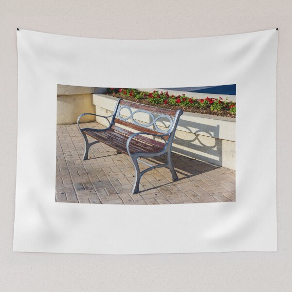 Item preview, Wooden And Metal Park Bench Casting Shadow Along Flowerbed On Sunny Pavement designed and sold by Nmallia.