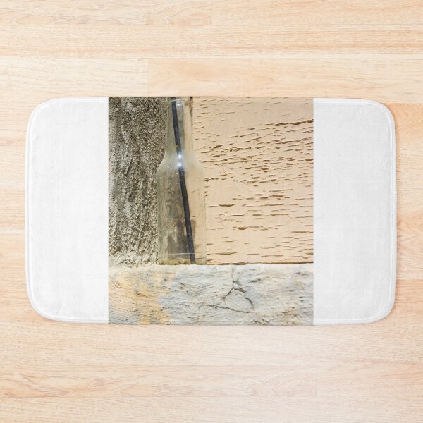 Item preview, Glass Bottle With Black Straw Against Textured Painted Wall On Concrete Ledge designed and sold by Nmallia.