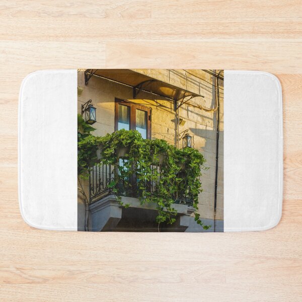 Item preview, Sunlit Balcony With Lush Green Vines Draping Over Iron Railing And Wooden Doors designed and sold by Nmallia.
