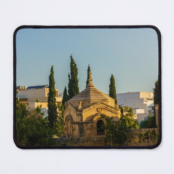 Item preview, Historic Stone Mausoleum Chapel With Cross Among Cypress Trees Overlooking Urban Landscape At Golden Hour designed and sold by Nmallia.