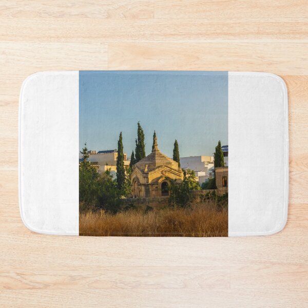 Item preview, Historic Stone Mausoleum Chapel With Cross Among Cypress Trees Overlooking Urban Landscape At Golden Hour designed and sold by Nmallia.