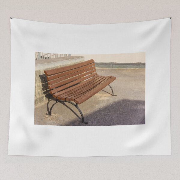 Item preview, Empty Wooden Bench in Sunlit Urban Park Beside Stone Wall on Asphalt Walkway Outdoor Seating designed and sold by Nmallia.