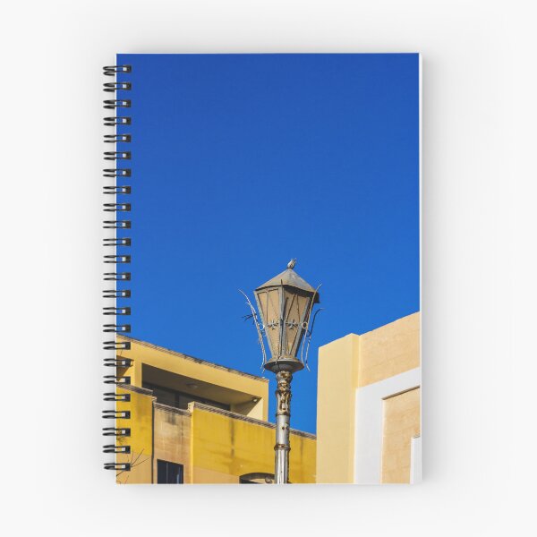 Item preview, Rustic Street Lamp Against a Bright Blue Sky and Modern Architecture designed and sold by Nmallia.