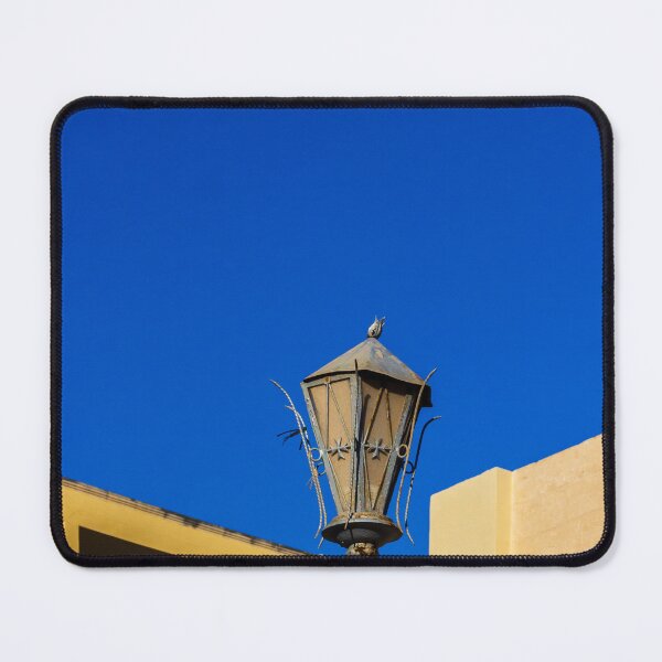 Item preview, Rustic Street Lamp Against a Bright Blue Sky and Modern Architecture designed and sold by Nmallia.