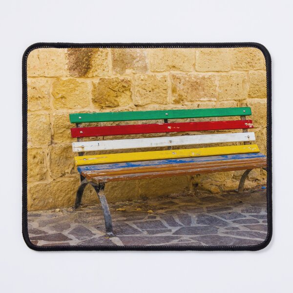Item preview, Colorful Painted Bench Against Rustic Stone Wall On Sunny Mediterranean Street designed and sold by Nmallia.