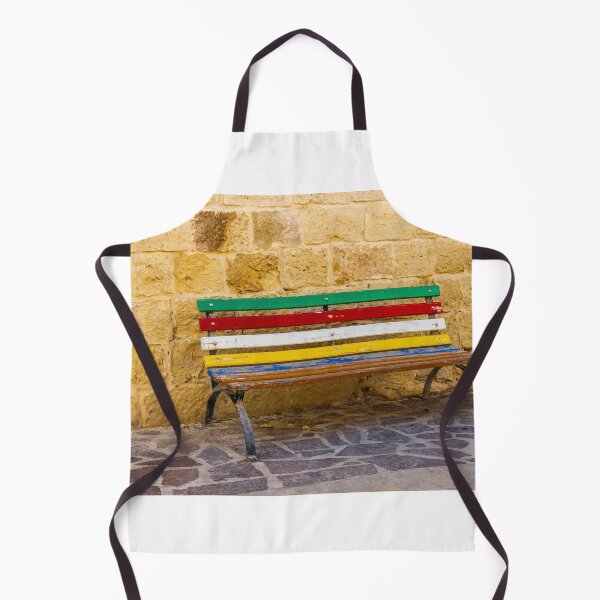 Item preview, Banco pintado de colores junto a un muro de piedra rústica en una soleada calle mediterránea. designed and sold by Nmallia.