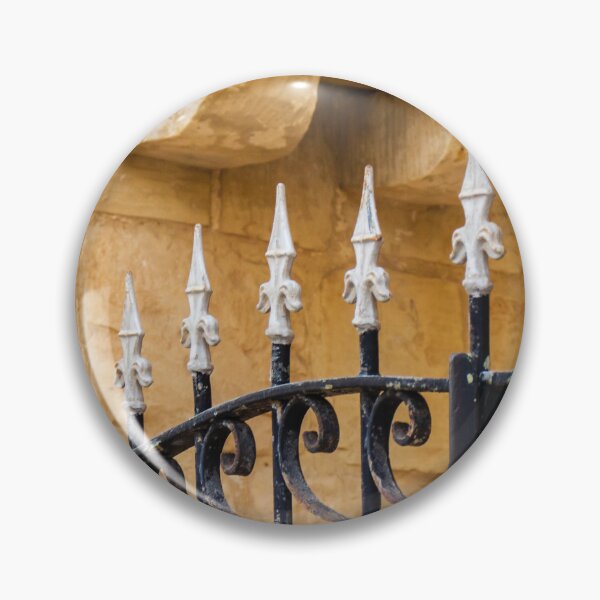 Item preview, Ornate Wrought Iron Fence With White Finials Against Warm Sandstone Wall In Historic Setting designed and sold by Nmallia.