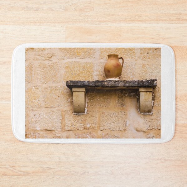 Item preview, Earthenware Jug On Stone Shelf Against Weathered Sandstone Wall In Mediterranean Village designed and sold by Nmallia.