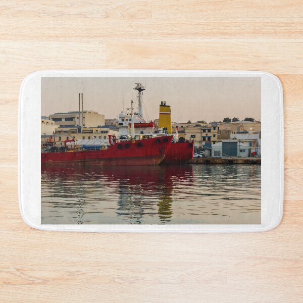 Item preview, Red Cargo Ship Docked at Industrial Harbor With Evening Reflections on Calm Water designed and sold by Nmallia.