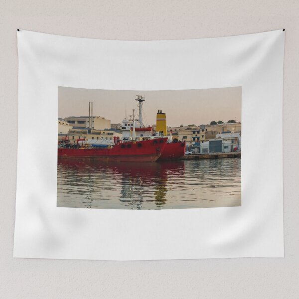 Item preview, Red Cargo Ship Docked at Industrial Harbor With Evening Reflections on Calm Water designed and sold by Nmallia.