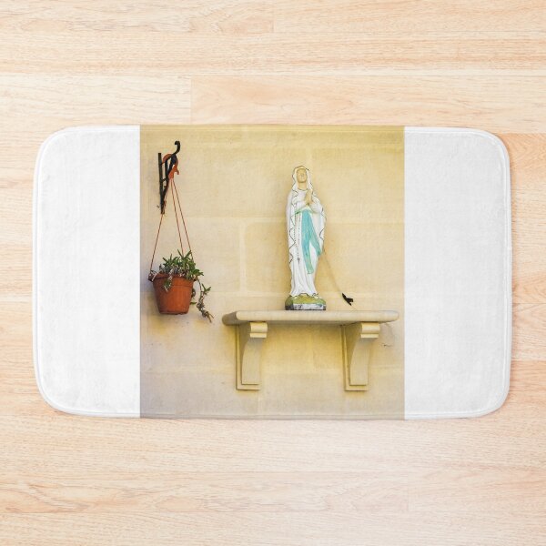 Item preview, Statue Of Virgin Mary On Shelf Beside Hanging Plant Against Light Beige Wall designed and sold by Nmallia.