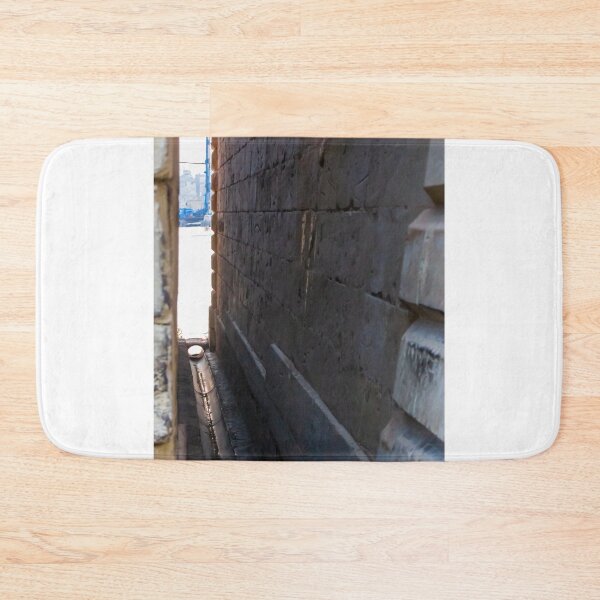 Item preview, Narrow Stone Dockside Gap With Water Channel and Industrial Harbor Visible in Background designed and sold by Nmallia.