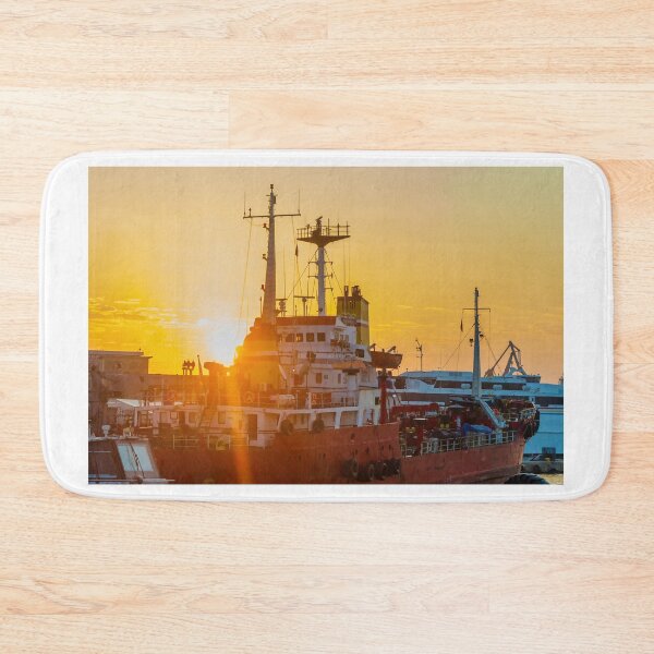 Item preview, Red Cargo Ship Docked at Harbor During Golden Sunset With Industrial Port Cranes in Background designed and sold by Nmallia.