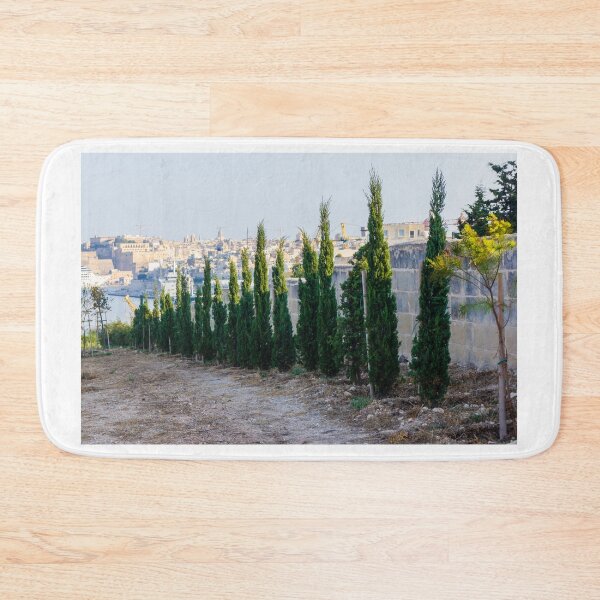 Item preview, Row Of Young Cypress Trees Along Stone Wall Overlooking Mediterranean Harbor And Historic Cityscape designed and sold by Nmallia.
