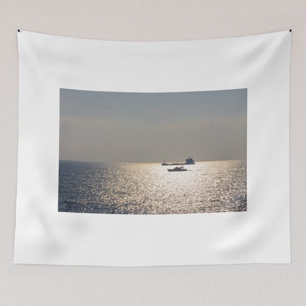 Item preview, Sunlit Ocean Horizon With Silhouetted Cargo Ship And Motorboat Crossing Glittering Water designed and sold by Nmallia.