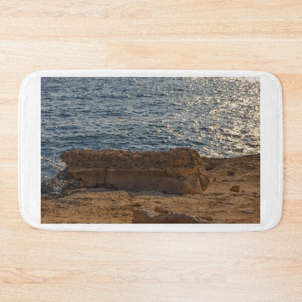 Item preview, Sunlit Coastal Rock Ledge Over Calm Ocean Waves With Sparkling Water at Sunset designed and sold by Nmallia.