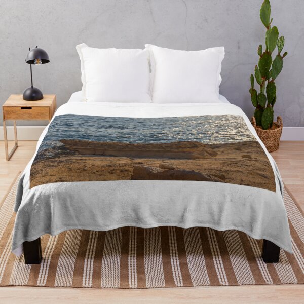 Item preview, Sunlit Coastal Rock Ledge Over Calm Ocean Waves With Sparkling Water at Sunset designed and sold by Nmallia.