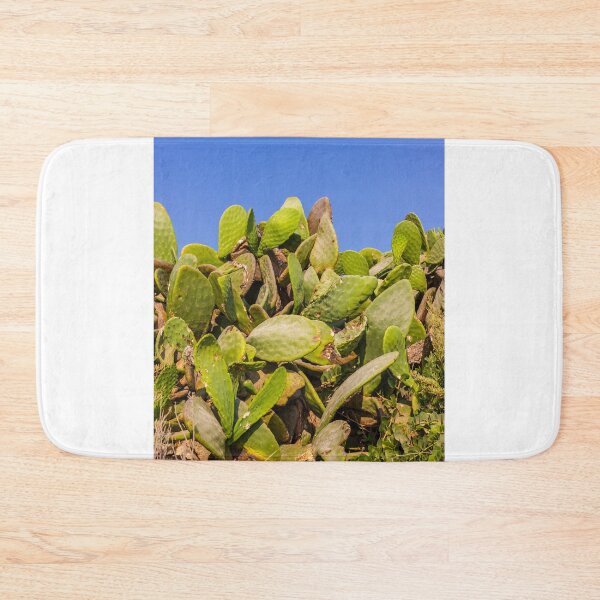 Item preview, Sunlit Prickly Pear Cactus Cluster Against Clear Blue Sky On Rocky Coastal Landscape designed and sold by Nmallia.