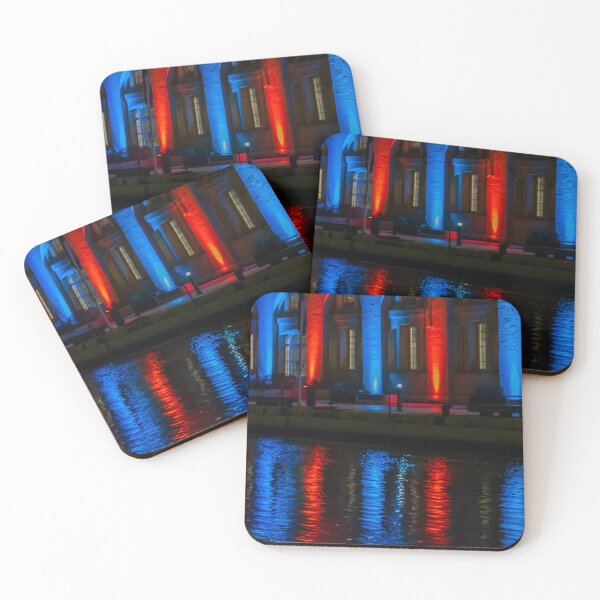 Item preview, Nighttime Waterfront Building With Red And Blue Illuminated Arches And Reflections On Water designed and sold by Nmallia.