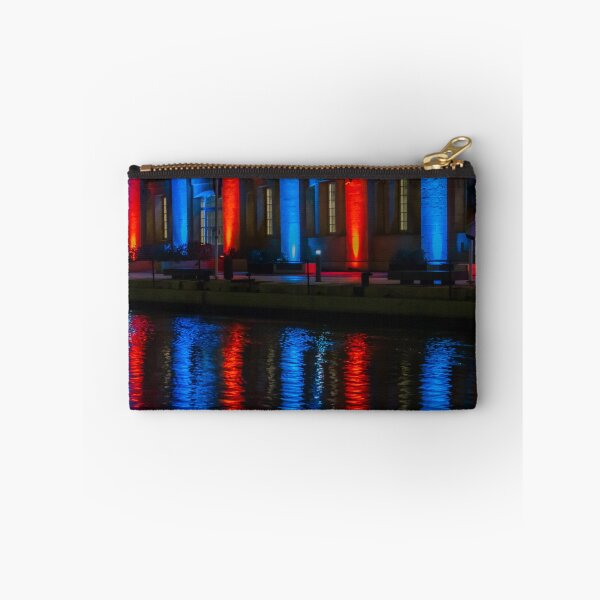 Item preview, Nighttime Waterfront Building With Red And Blue Illuminated Arches And Reflections On Water designed and sold by Nmallia.
