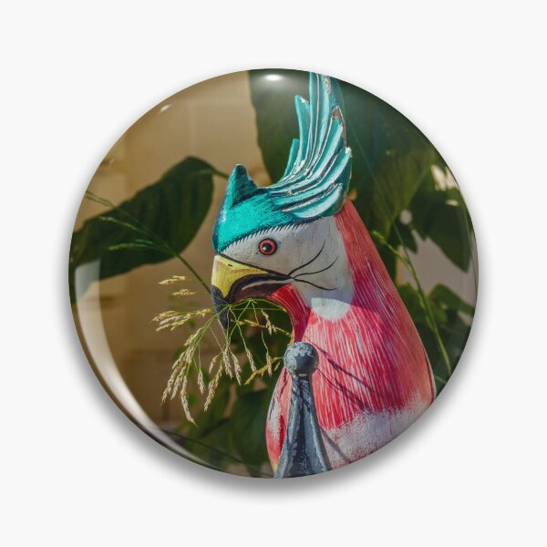 Item preview, Colorful Painted Bird Statue Perched on a Weathered Metal Fence Amid Lush Greenery designed and sold by Nmallia.