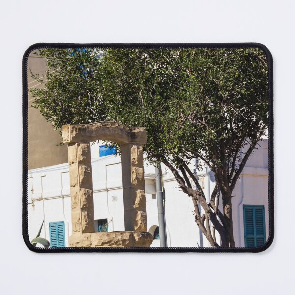 Item preview, Sunlit Stone Archway Garden With Olive Tree, White Mediterranean Buildings And Blue Shutters designed and sold by Nmallia.