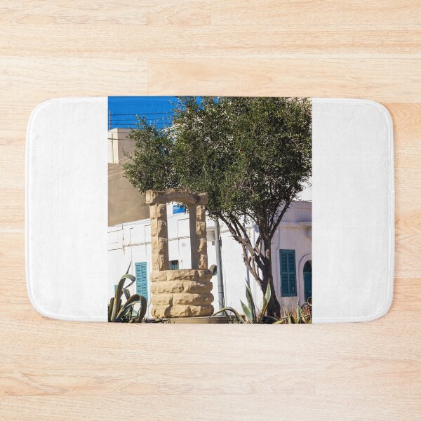 Item preview, Sunlit Stone Archway Garden With Olive Tree, White Mediterranean Buildings And Blue Shutters designed and sold by Nmallia.