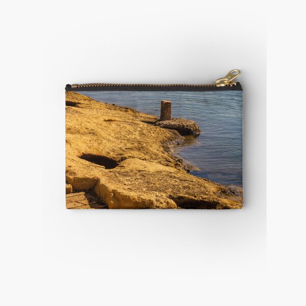Item preview, Rugged Coastal Rocks By Calm Blue Water With Weathered Stone Pier And Small Post designed and sold by Nmallia.