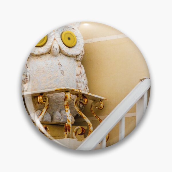 Item preview, Whimsical Stone Owl Statue With Yellow Eyes Guarding Rusty Railing Above Beige Wall designed and sold by Nmallia.