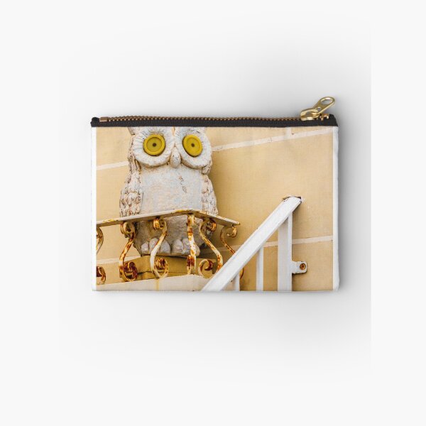 Item preview, Whimsical Stone Owl Statue With Yellow Eyes Guarding Rusty Railing Above Beige Wall designed and sold by Nmallia.