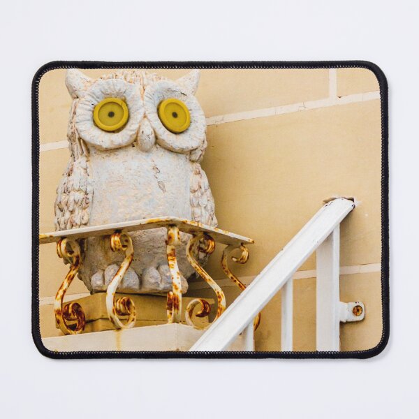 Item preview, Whimsical Stone Owl Statue With Yellow Eyes Guarding Rusty Railing Above Beige Wall designed and sold by Nmallia.