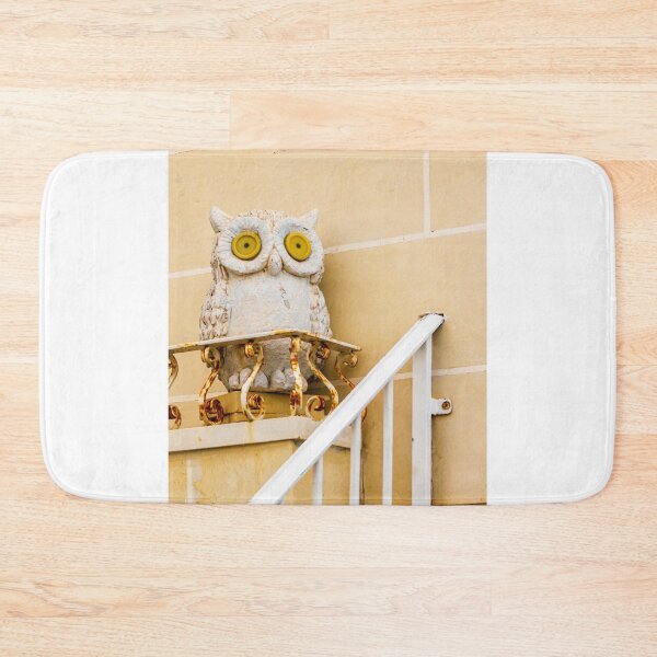 Item preview, Whimsical Stone Owl Statue With Yellow Eyes Guarding Rusty Railing Above Beige Wall designed and sold by Nmallia.