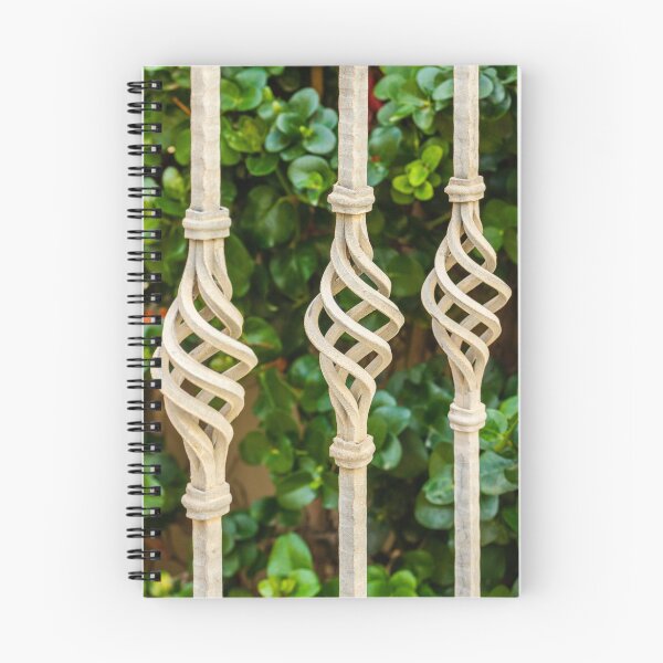 Item preview, Decorative Twisted Iron Fence Bars With Vertical Rods Over Lush Green Hedge Behind Wall designed and sold by Nmallia.