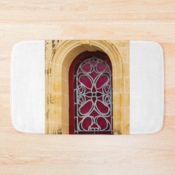 Item preview, Elegant Arched Stained Glass Window With Intricate Ironwork On Warm Stone Facade designed and sold by Nmallia.