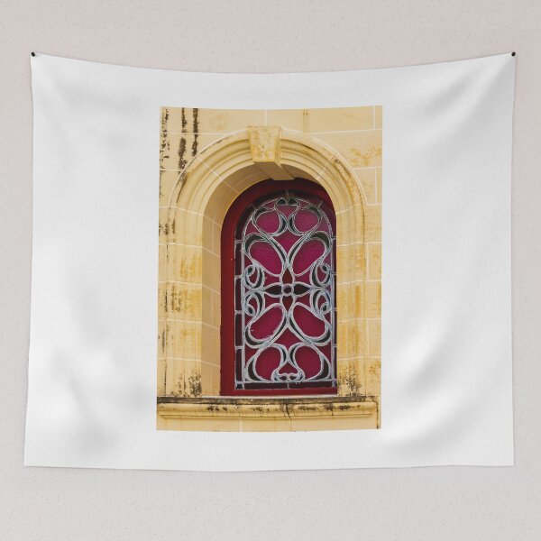 Item preview, Elegant Arched Stained Glass Window With Intricate Ironwork On Warm Stone Facade designed and sold by Nmallia.