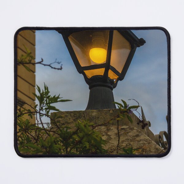 Item preview, Vintage Streetlamp With Warm Glow Over Stone Wall Amid Ivy And Evening Sky designed and sold by Nmallia.