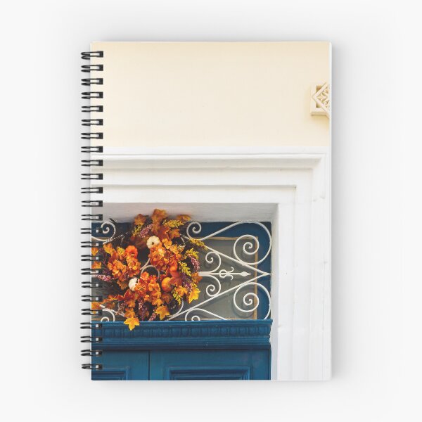 Item preview, Autumn Wreath Adorns Blue Door With White Ornate Grille On Sunlit Wall designed and sold by Nmallia.