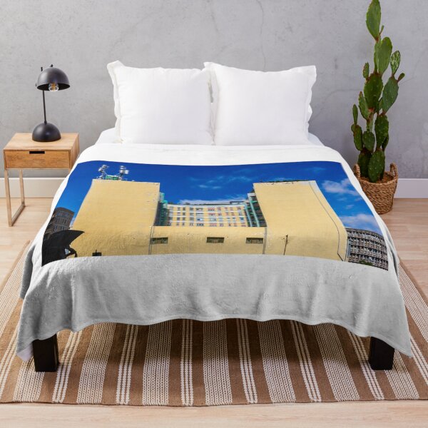 Item preview, Yellow Building With Curved Center Facade And Rooftop Antennas Under Bright Blue Sky designed and sold by Nmallia.