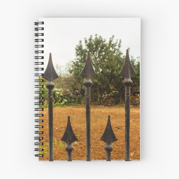 Item preview, Rusty Iron Fence Spikes In Front Of A Garden Yard With Greenery Background designed and sold by Nmallia.